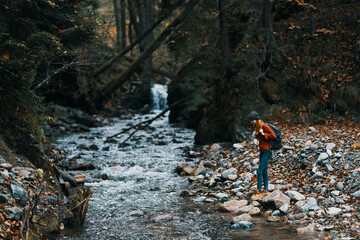 Obraz premium woman in a sweater hat near the river and trees in the background