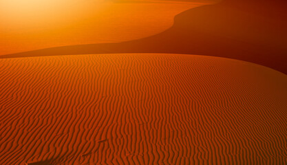 Orange ripple sand dune desert at sunset