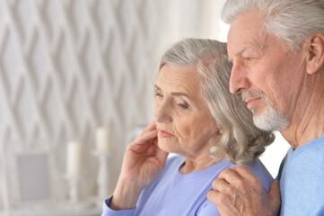 Portrait of sad senior couple posing at home