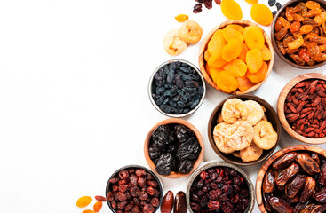 Healthy food snack: natural sun dried fruits mix in bowls on white background, top view