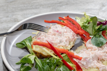 Seafood cocktail on baked potato. Healthy lunch with salad close-up