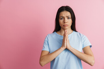 Hispanic unhappy woman holding hands together and looking at camera