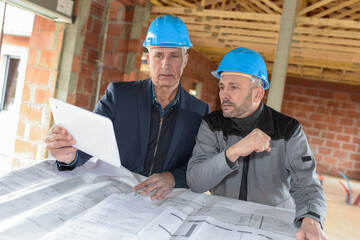 Architect and contractor checking the plans on a construction site