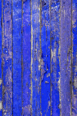 wall of old wooden boards is painted with cracked paint