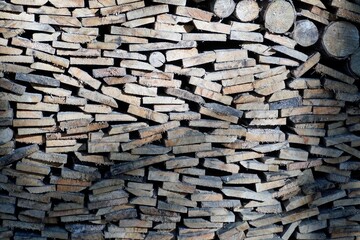 The ends of the stacked firewood for a fireplace or barbecue. Texture. Background