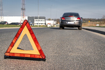 Broken down car. Vehicle engine motor problem concept. Auto accident triangle on road.