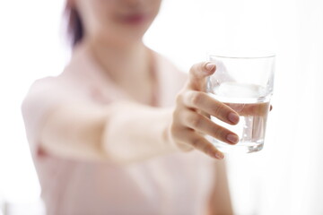 Young woman holding glass of water
