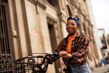 Happy young woman riding bicycle in the city. Woman enjoying outdoors..