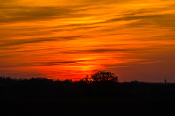 Fototapeta na wymiar Sunset behind the hills with an orange sky