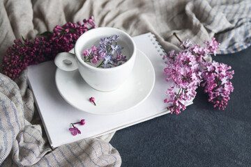 Spring romantic background with lilac flowers, with a notebook for sketches on a background of...