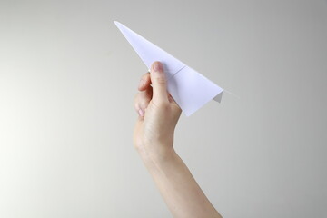 Close up of woman holding paper airplane