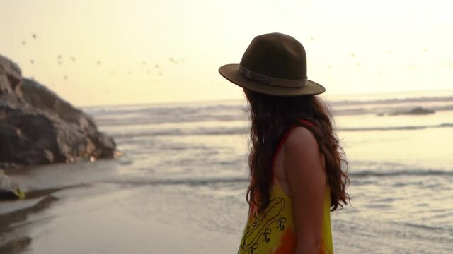 young woman admiring sea at sunset . female walking and contemplating seascape slow motion