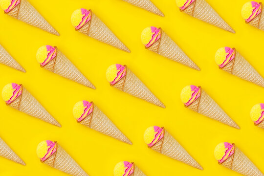 Pattern Of Sweet Yellow Pink Fruit Ice-cream Sorbet In A Waffle Cone With Banana And Strawberry Flavor Isolated On A Bright Color Yellow Background. Lots Of Ice Cream Cones. Summer Concept