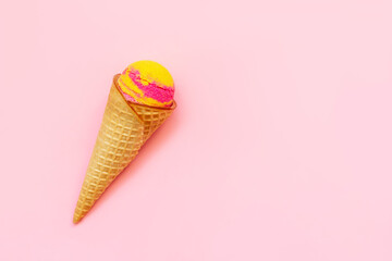 Sweet yellow pink fruit ice-cream sorbet in a waffle cone with banana and strawberry flavor...