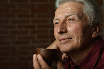 Portrait of smiling senior man drinking coffee  at home