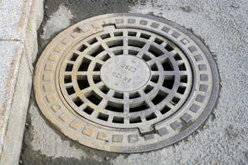 Manhole cover on the road in the asphalt