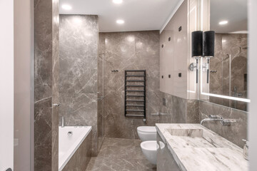 Modern minimalist bathroom beige interior design with marble tiles and glossy beige furniture