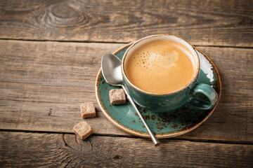 Cup of hot coffee on wooden table