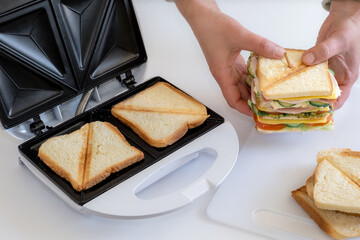sandwich toaster toast bread slice hand fry hold biscuit cheese morning - obrazy, fototapety, plakaty