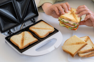 sandwich toaster toast bread slice hand fry hold biscuit cheese morning