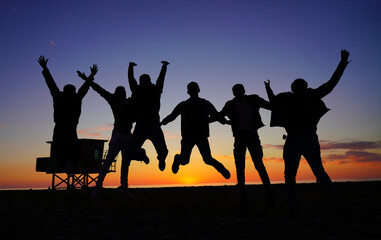 Fototapeta na wymiar people jumping on the background of the sunset