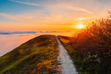 Bright sunset, clouds and mountain with trail
