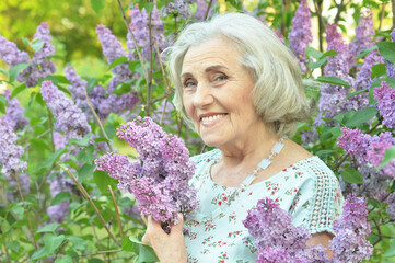 happy  senior beautiful woman with lilacs