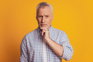 Aged man with hand on beard looking up thinking