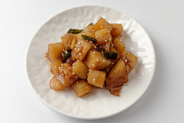 Simmered potatoes in soy sauce on a white background