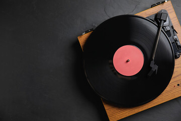 Modern vinyl record player with disc on black background, top view. Space for text - Powered by Adobe
