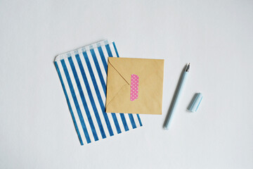 Paper bag, kraft envelope, washi tape and pen on white background