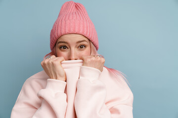 Young white woman smiling and hiding her face behind sweatshirt