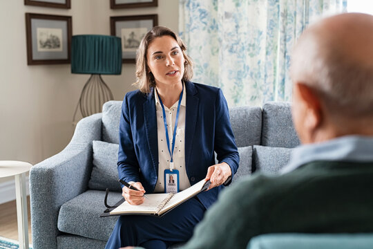 Social worker talking with senior man during home visit