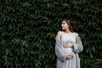 Young pregnant woman hugging herself