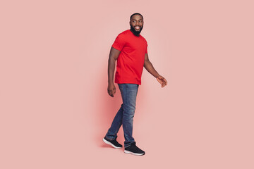 Fototapeta premium Afro american guy go empty space pink color background