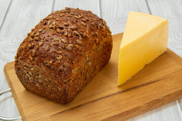 Loaf of bread on wooden cutting board on white background