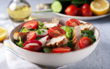 Grilled chicken breast, fillet and fresh vegetable salad of lettuce, spinach, cucumber and tomato