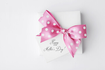 gift box with pink ribbon bow and a note. Mothers Day gift