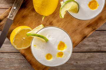 Pisco sour cocktail on rustic wooden table. Traditional peruvian cocktail