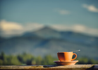 A cup of tea against the backdrop of a mountain landscape. Camping. 
