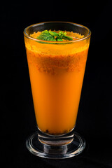 Sea buckthorn and sea buckthorn juice in glass isolated on black background.