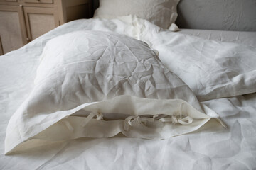 Fototapeta na wymiar Trendy organic natural linen bedclothes with wooden buttons closeup