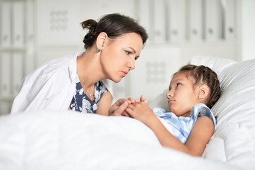 sad woman with daughter in hospital ward