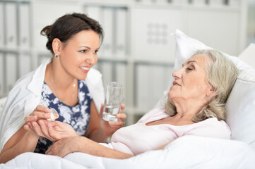 Senior woman in hospital with caring daughter