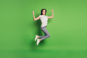 Fototapeta na wymiar Full size photo of jumping woman over green background