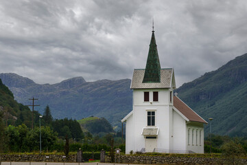 Fototapeta na wymiar Beautiful white wooden Dirdal church among mountains in Rogaland