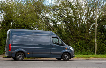 Hampshire, England, UK. 2021. Blue coloured commercial van driving along a main road in Hampshire, UK.