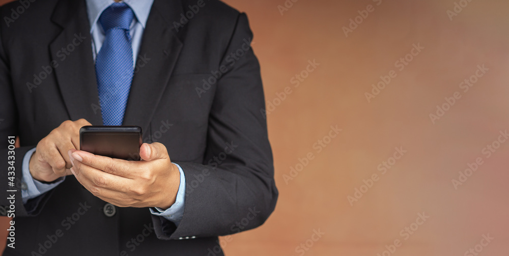 Poster businessman using a smartphone while standing with a brown background. space for text. communication