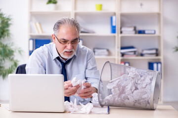Fototapeta premium Old businessman rejecting new ideas with lots of papers