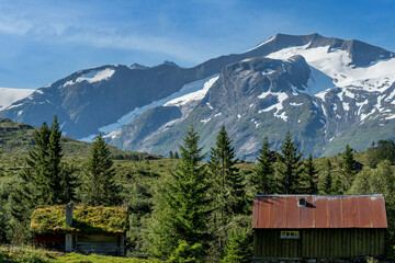 Fototapeta na wymiar Norwegian cottage in the wild nature with big mountains.